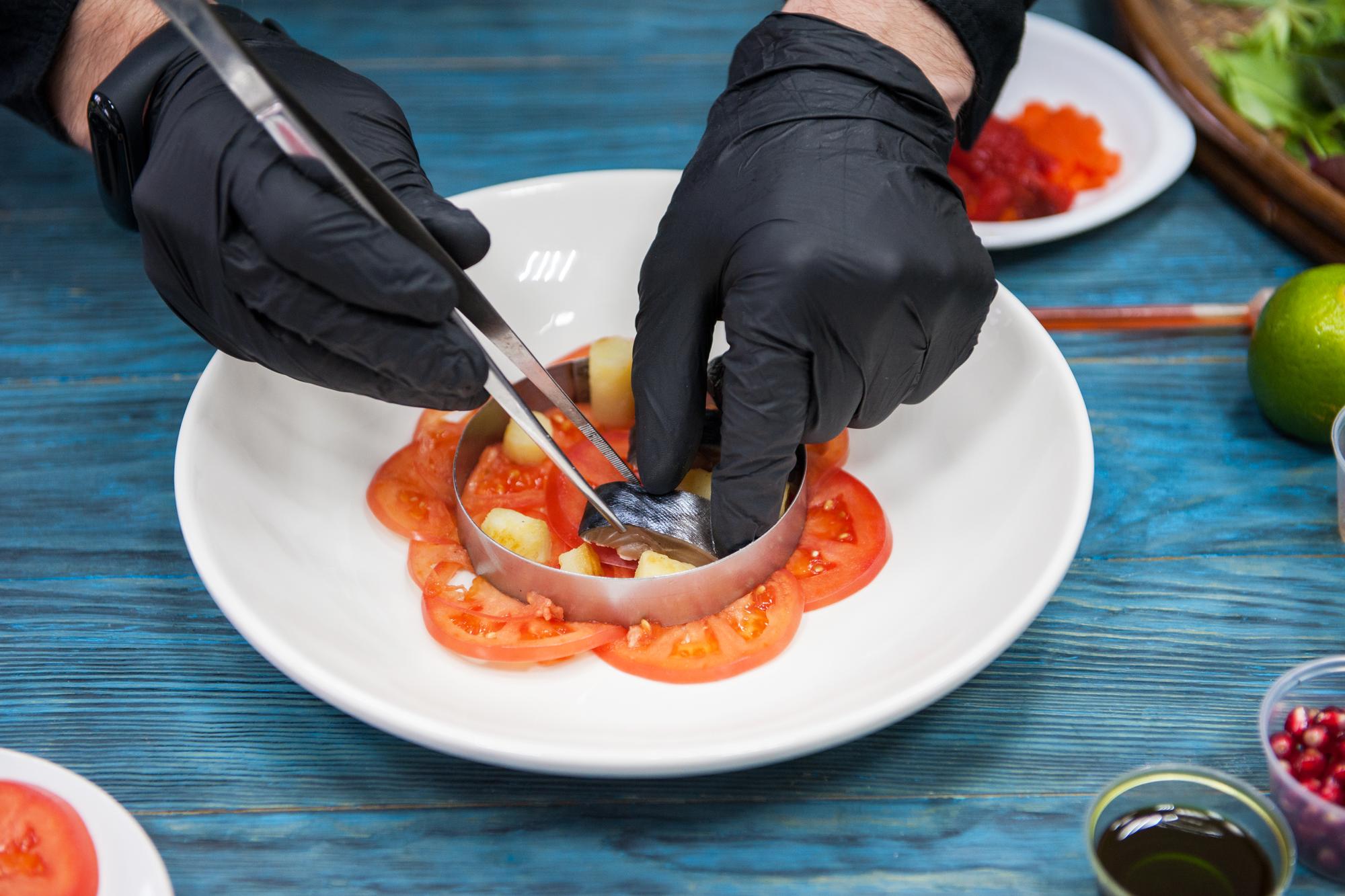Hands preparing delicate garnish with tweezers